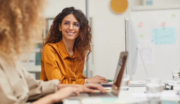 Image d'une femme souriante en train d'utiliser son ordinateur
